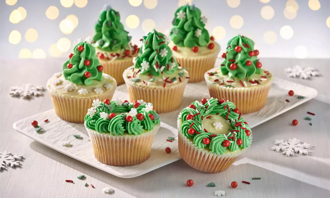 Weihnachtliche Cupcakes mit Frischkäse-Topping und dekorativen Tannenbäumen – einfaches Rezept für festliche Stimmung und süßen Genuss zur Weihnachtszeit.