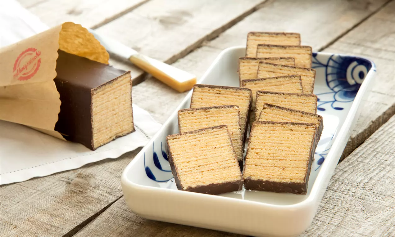 Klassisches Baumkuchen Rezept, auch Grill- oder Schichtkuchen genannt, mit Rum im Teig und einem zarten Schokoladenguss - Baumkuchen backen.