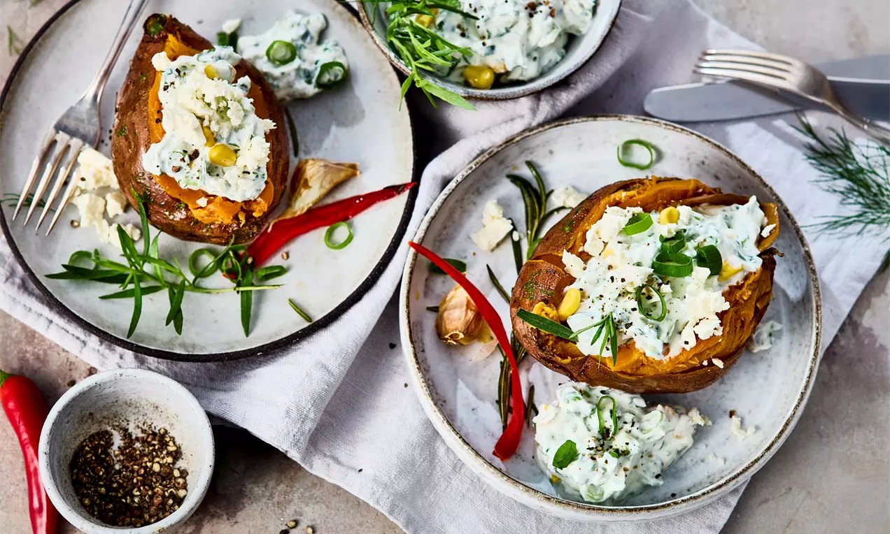 Teller mit Süßkartoffeln aus dem Ofen mit zarter Kruste, weichem Kern und würziger Marinade, Gemüsequark – einfaches Rezept für gesunde Beilage oder Snack mit Feta und Kräutern.