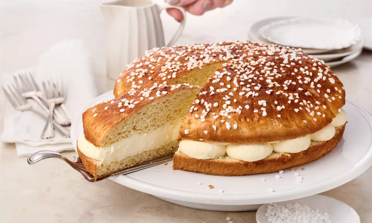 Tarte Tropézienne aus fluffigem Briocheteig mit Hagelzucker und cremiger Puddingfüllung – der französische Klassiker aus St. Tropez, einfach selbst gebacken für besonderen Genuss.
