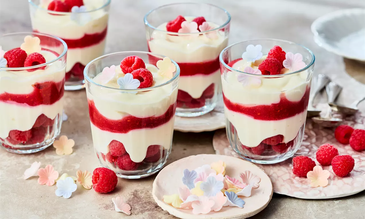 Esspapierblüten auf Himbeer-Quark-Dessert mit frischem Himbeerpüree und cremiger Quarkspeise – einfaches, fruchtiges Dessert im Glas für jeden Anlass, schnell gemacht und lecker.