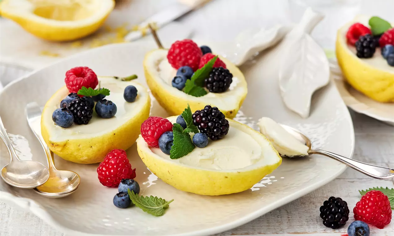 Lemon Posset klassisch serviert in halben Zitronen – cremiges Zitronen-Dessert mit Sahne und frischem Zitronensaft. Einfaches Sommerdessert, fruchtig, erfrischend und schnell gemacht!
