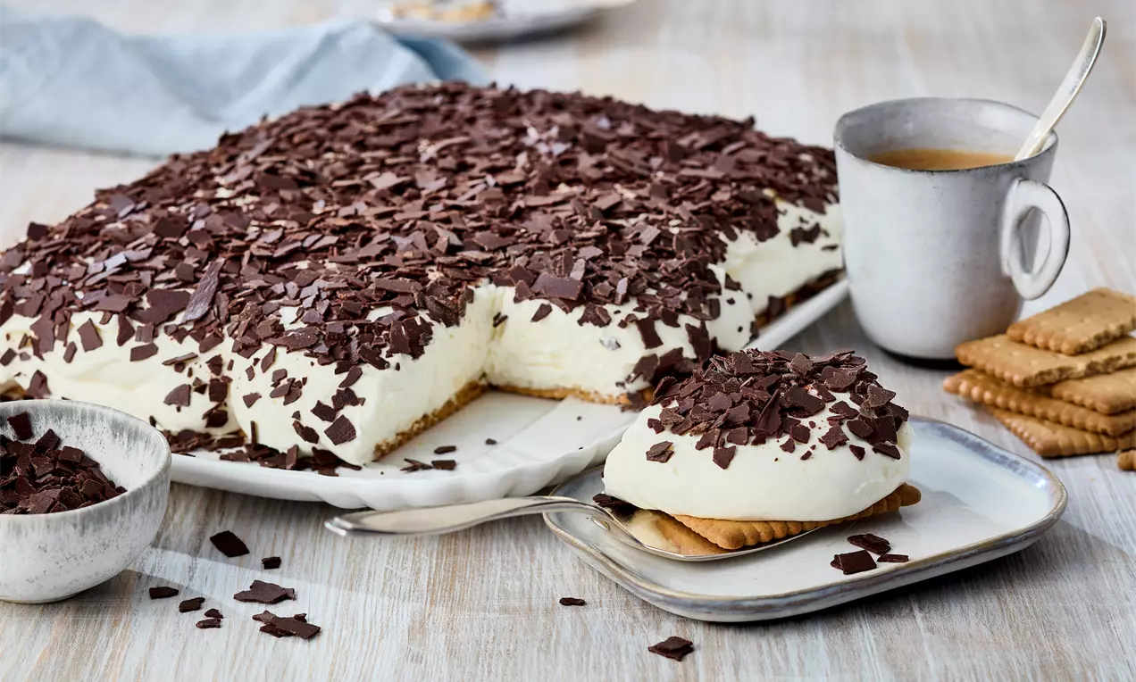 Schaumkuchen angeschnitten mit Paradiescreme Weiße Schokolade und Butterkeksen – luftiger, cremiger Kuchen ohne Backen. Einfaches Rezept für süßen Genuss auf der Kaffeetafel.