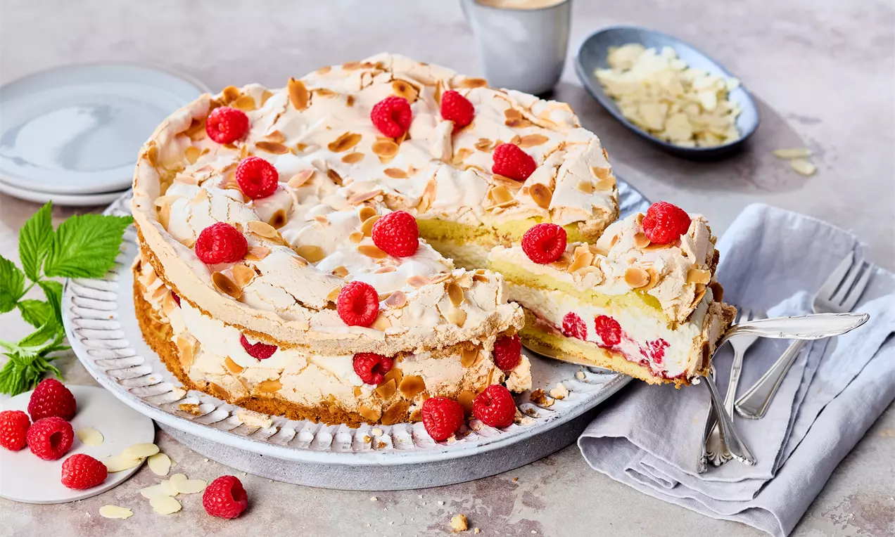 Ansicht von oben: Himbeer-Baisertorte mit knusprigem Baiser, Sahne-Schmand-Creme und frischen Himbeeren – fruchtiges Tortenrezept mit Mandel-Note, ideal für besondere Anlässe