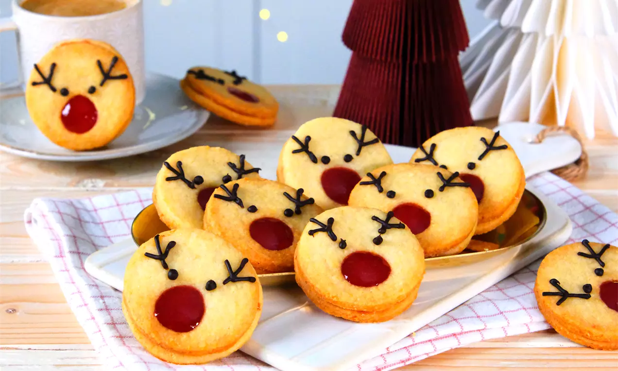 Fruchtige Spitzbuben verziert als Rentier zu Weihnachten. Das Rentier Spitzbuben Rezept mit Marmelade ist ein Keks-Klassiker und ganz einfach zu backen.