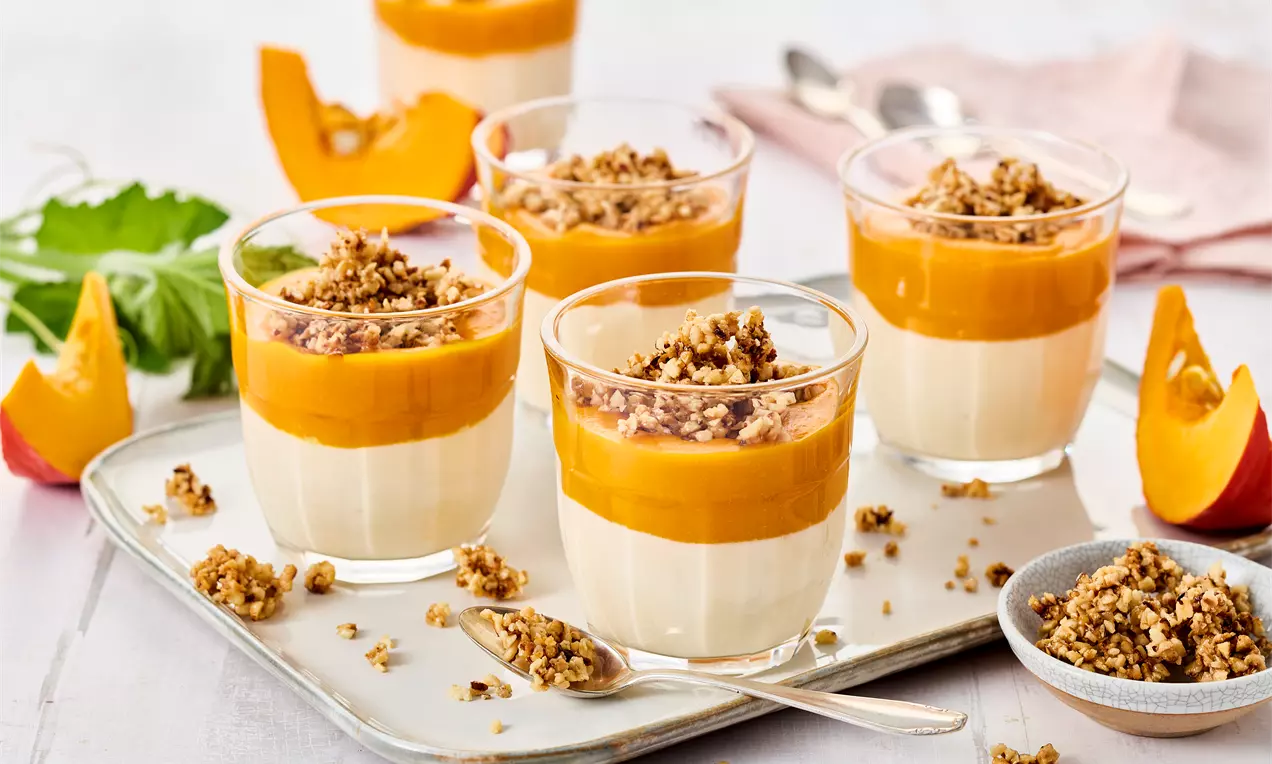 Kürbis-Dessert mit Quarkcreme, Kürbispüree und Haselnuss-Krokant – einfaches Herbstrezept mit Zimt, Ahornsirup und frischer Orange für süßen Genuss.
