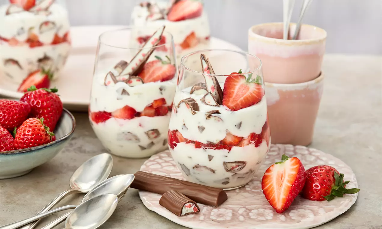 Yogurette® Dessert mit geschichteter Joghurtcreme, frischen roten Erdbeeren und zarten Schokoladenraspeln im Glas serviert