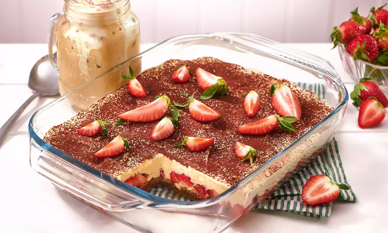 Erdbeer-Tiramisu mit Schichten aus cremiger Mascarpone, goldbraunen Löffelbiskuits und leuchtend roten Erdbeerscheiben, dekorativ angerichtet
