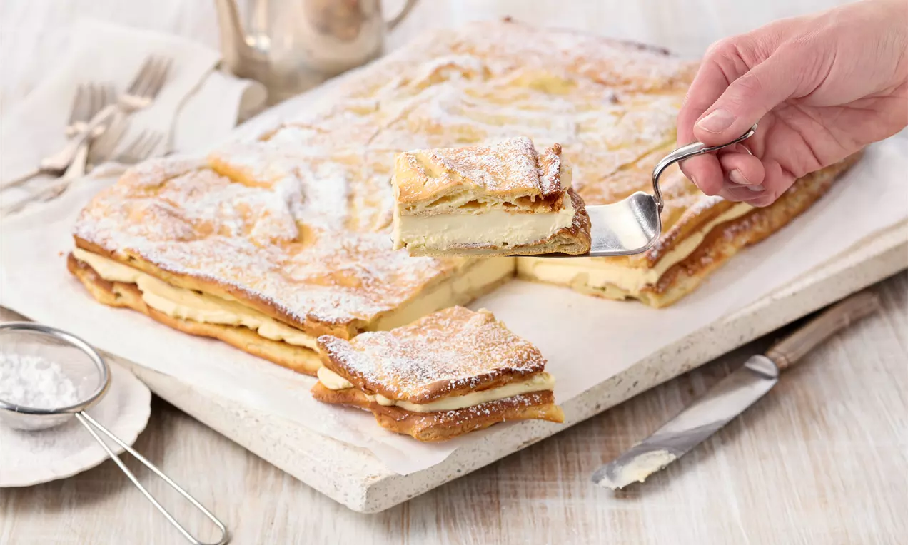Karpatka – polnischer Windbeutelkuchen vom Blech aus luftigem Brandteig, gefüllt mit cremiger Buttercreme. Einfaches Rezept für Blechkuchen, lecker und schnell gemacht.