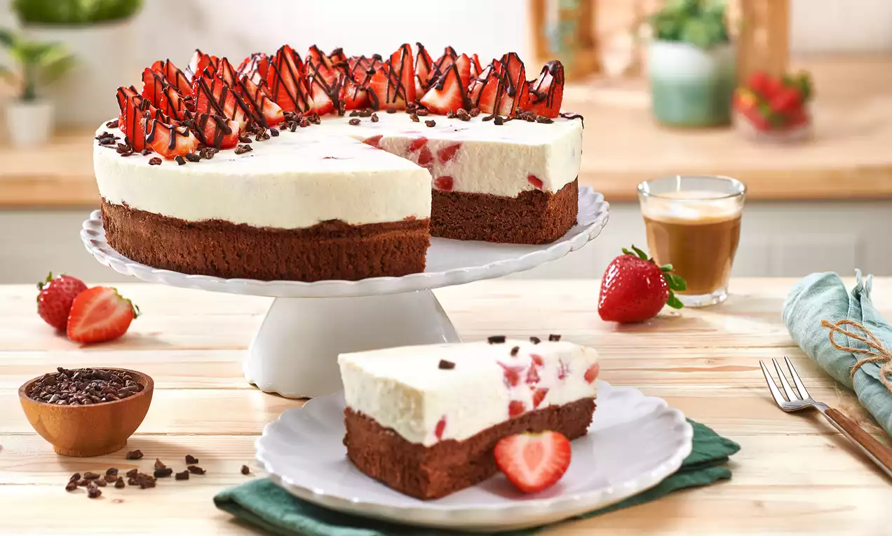 Erdbeer-Schoko-Kuchen mit weißer Sahnecremeschicht auf schokoladenbraunem Boden, dekoriert mit frischen Erdbeeren und dunkler Schokoglasur