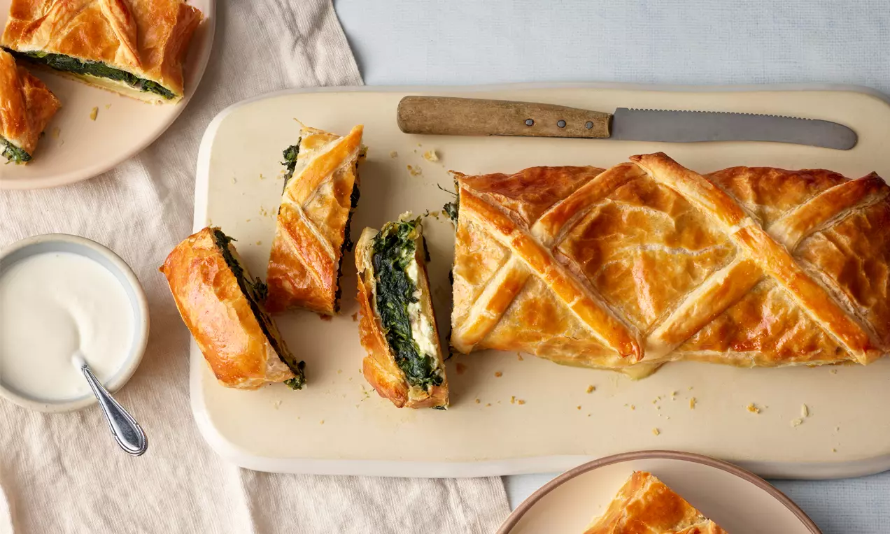 Spinatstrudel mit Schafskäse: goldbrauner Blätterteig, grüne Spinatfüllung mit weißen Feta-Stücken und frische Kräuter