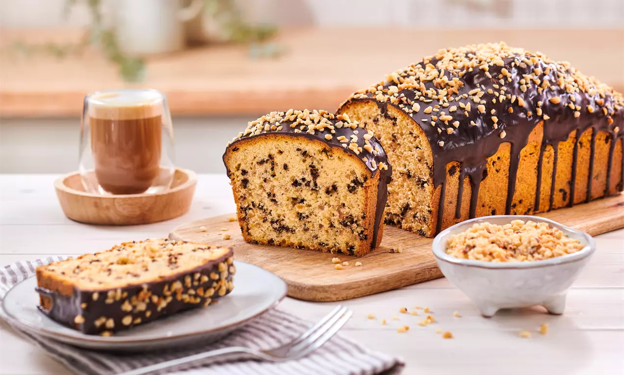 Schokino-Nuss-Kuchen mit Schokostücken und Haselnüssen – saftiger Kastenkuchen mit Glasur, einfach gebacken und perfekt zum Kaffee oder als süßer Snack.